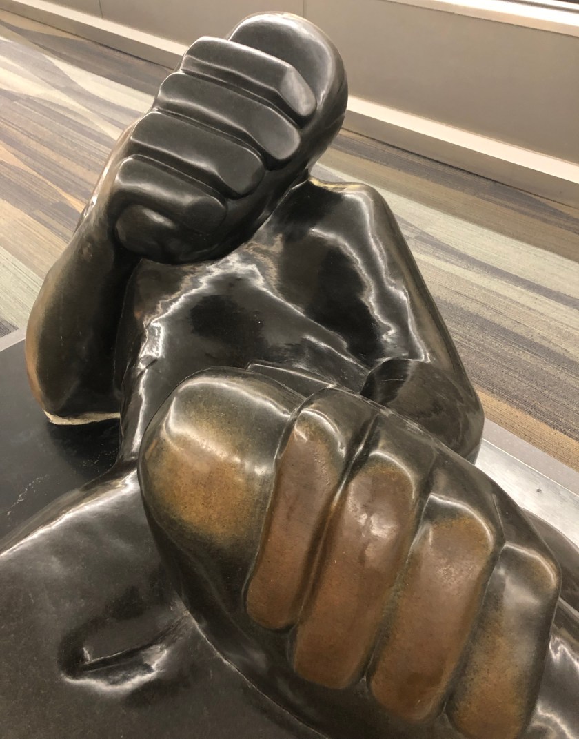 Man covering face sculpture, Atlanta airport