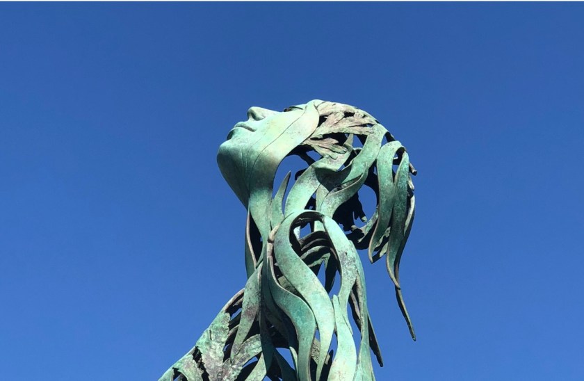 Metal female sculpture looking up, Laguna Beach, CA