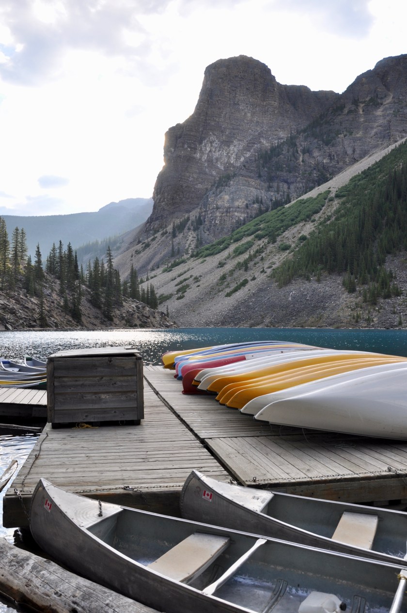 Empty canoes lined up at lake, ready to go, Canadian rockies